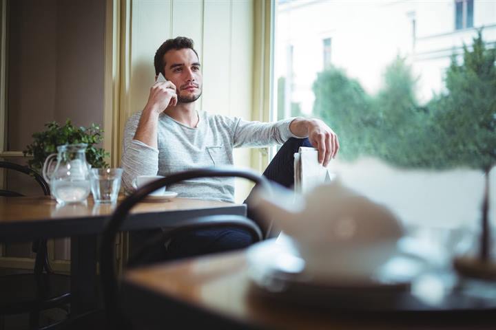 Business owner speaking on a phone by a window