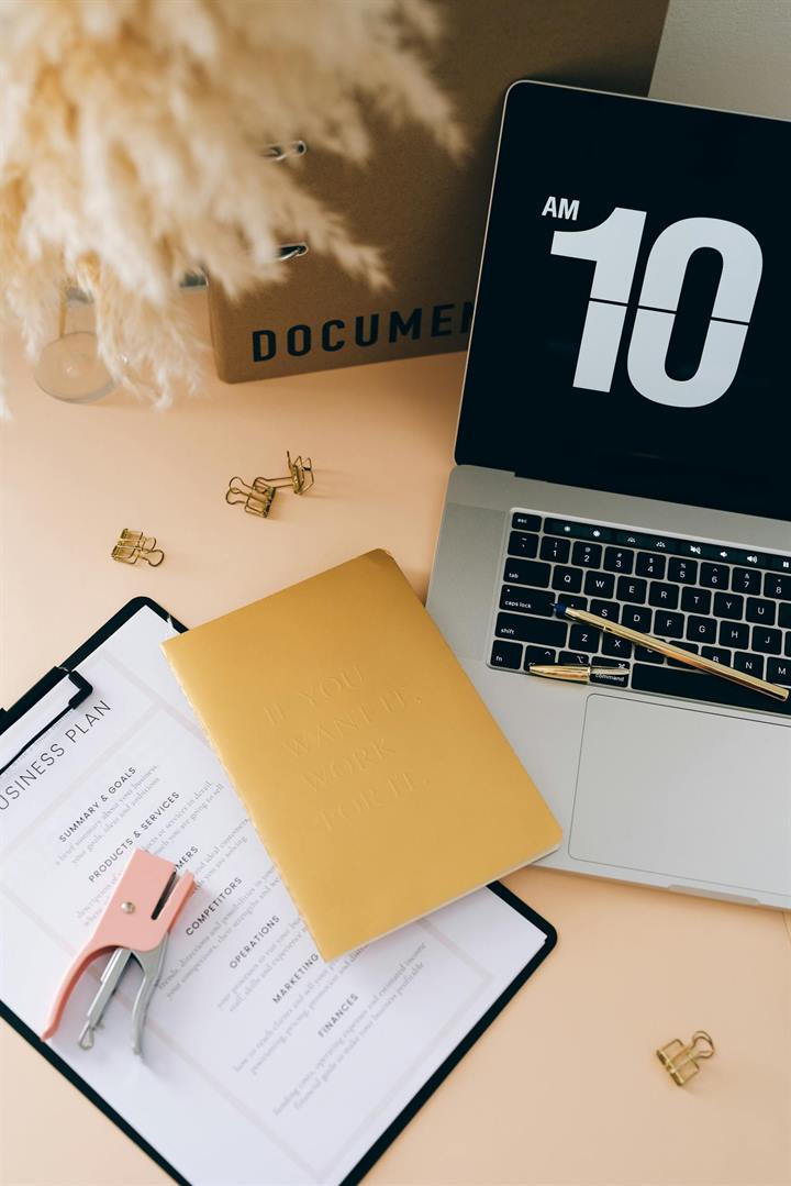 Desk with business plan notes and laptop
